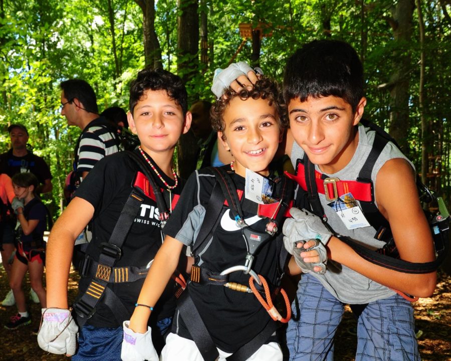 three brothers wearing harnesses and gloves before ziplining