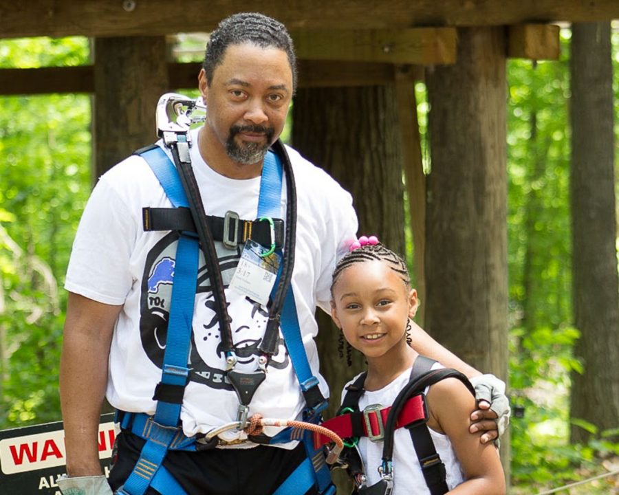 father and daughter smiling at adventure park