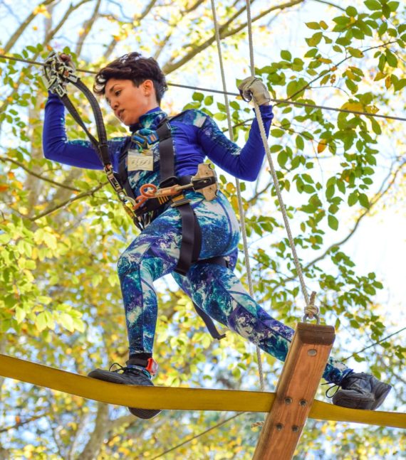 Woman crossing high ropes course