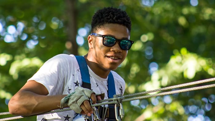 Young man crossing ropes course